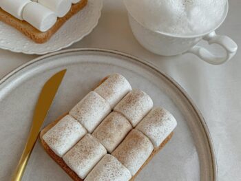 toast with marshmallows beside a cup with milk foam