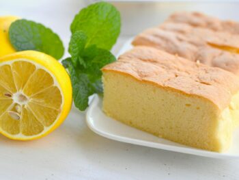 close up view of sliced sponge cake on a plate beside a lemon