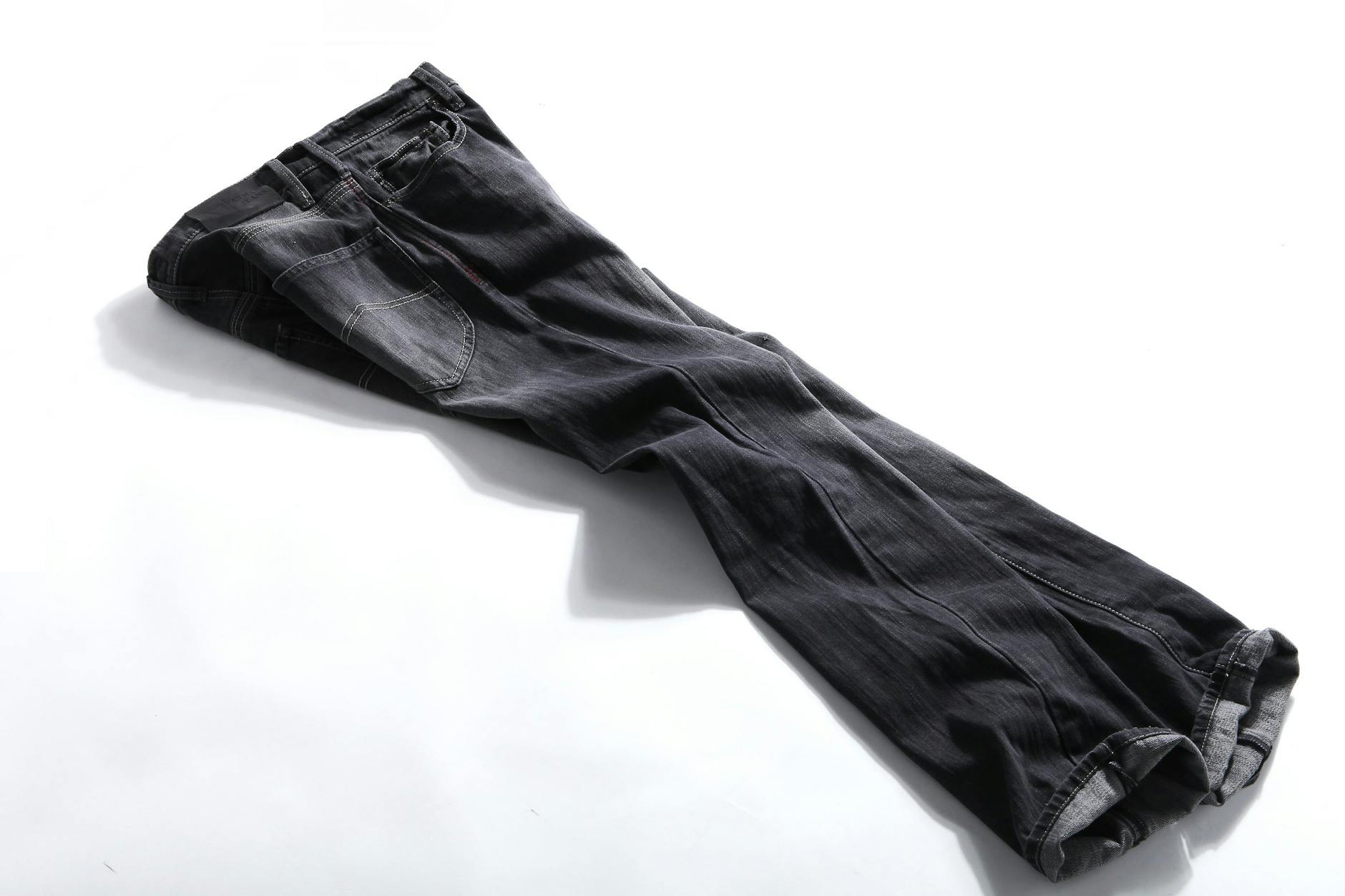 black denim jeans on white panel