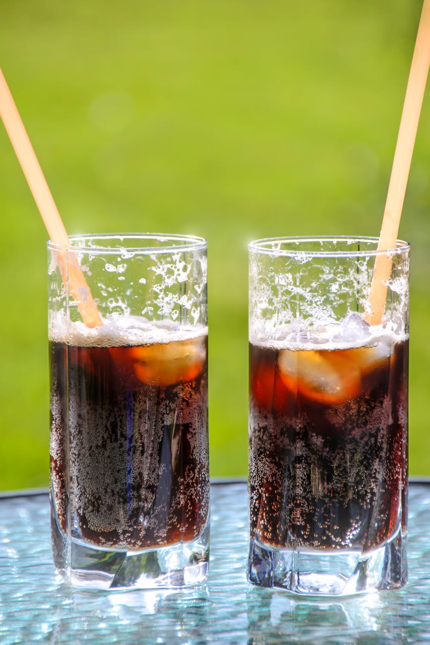 two glasses with beverage and straws