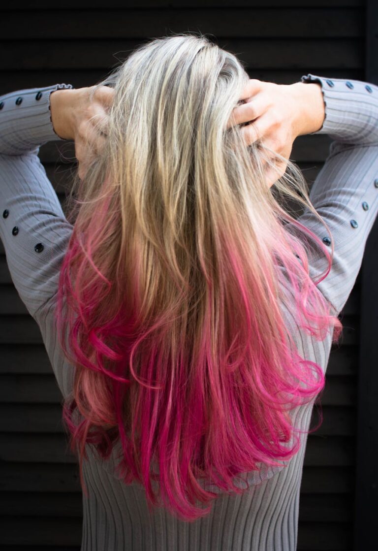 woman in gray long sleeved top holding hair