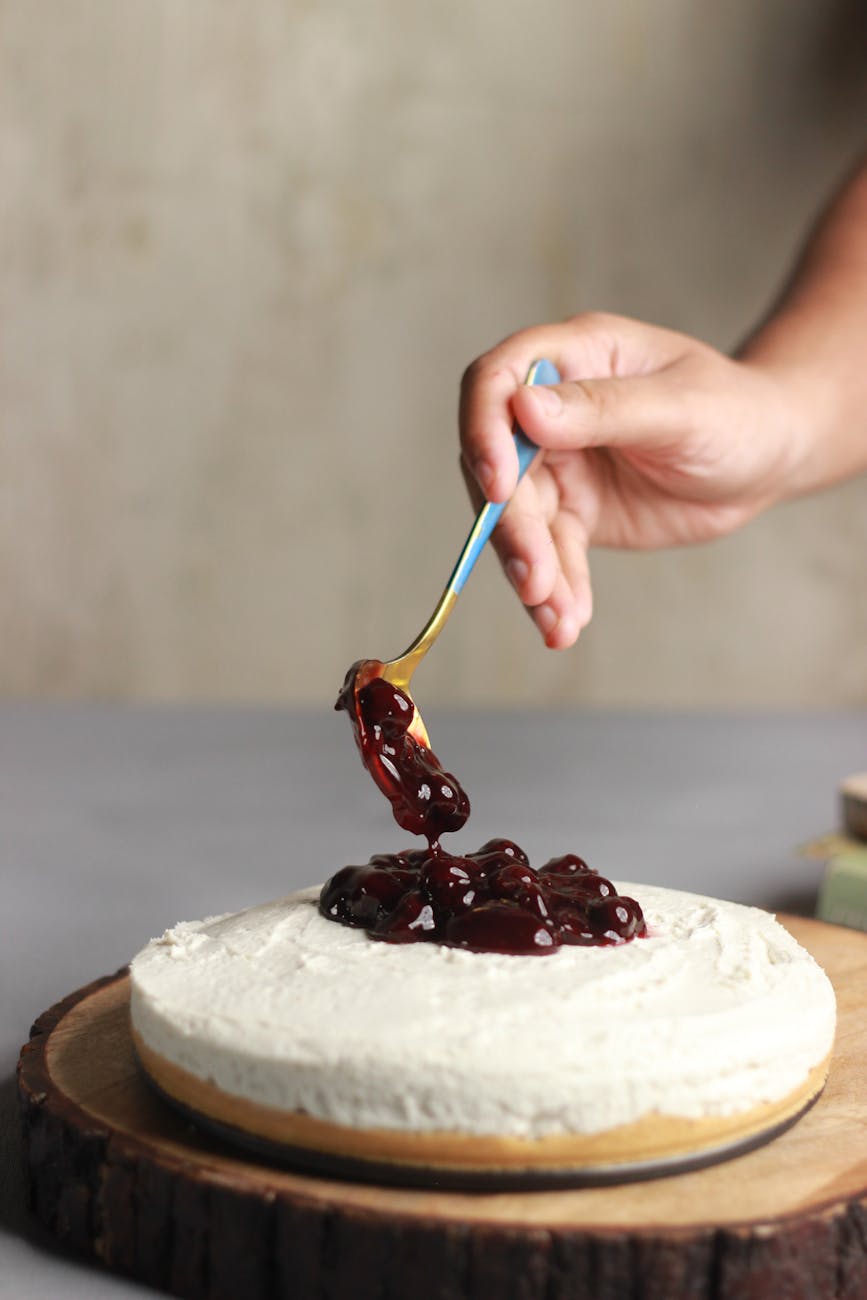 a person adding toppings on a cheesecake
