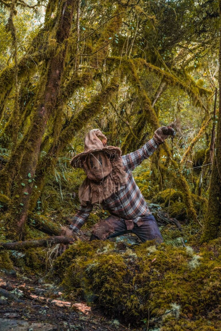 person dressed in a scarecrow halloween costume posing in a forest