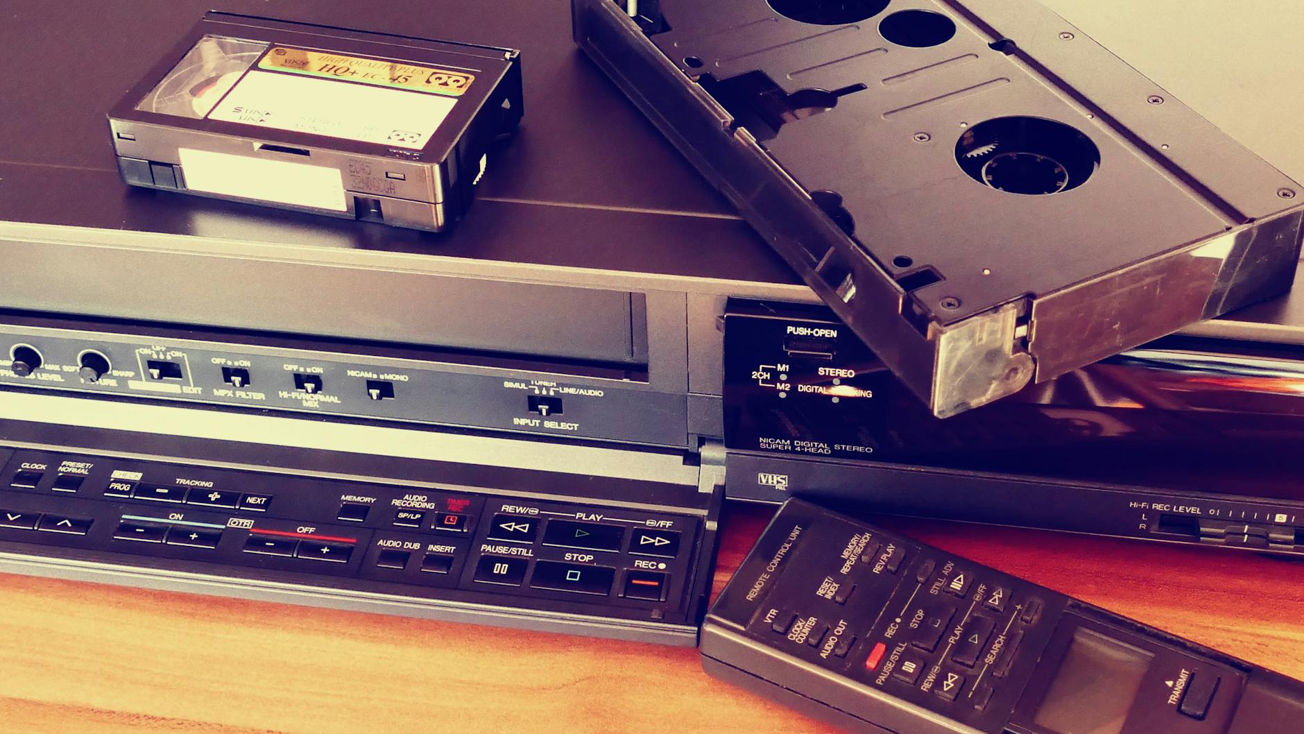 black vhs on vhs player beside remote control