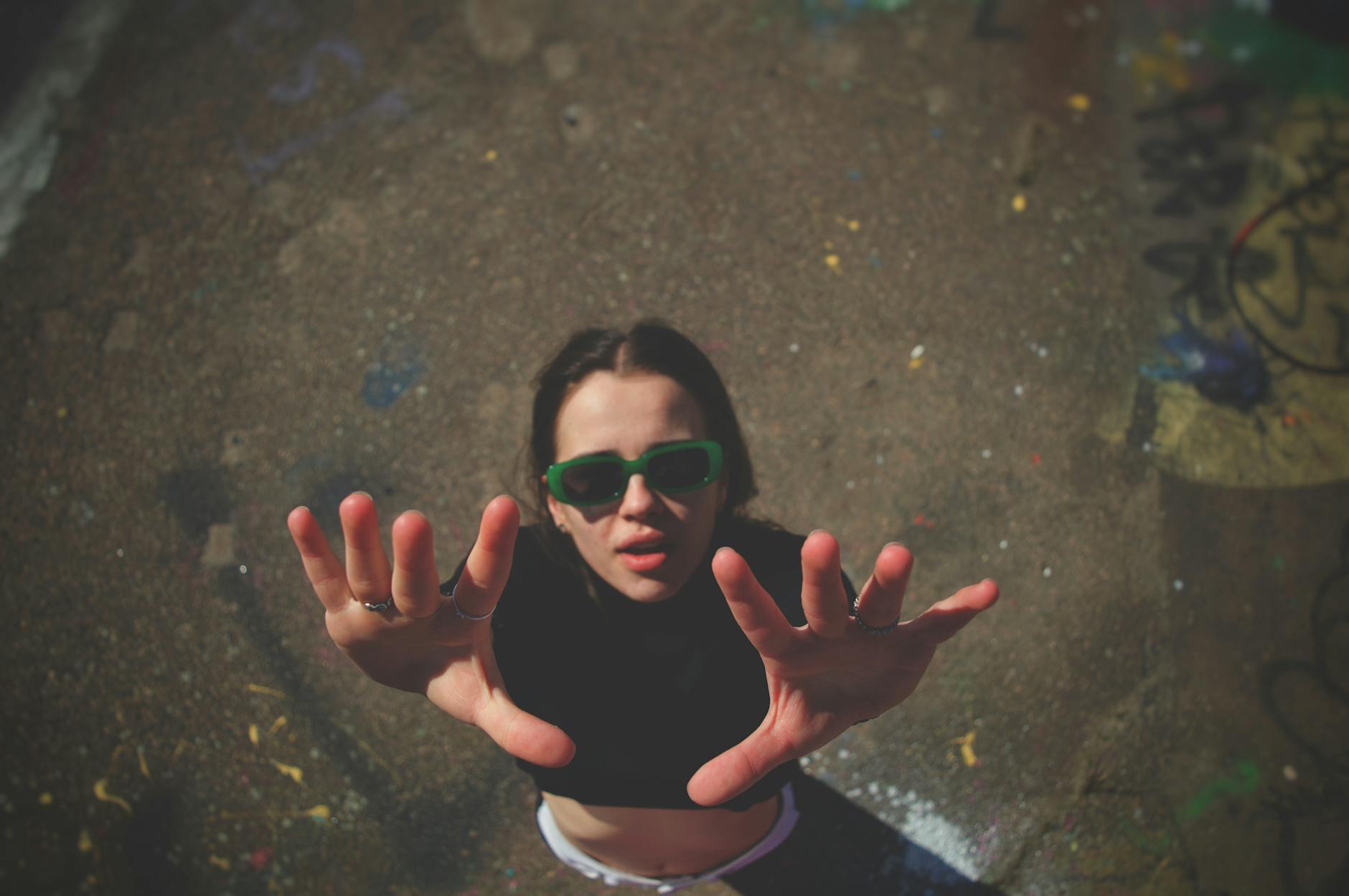 woman in sunglasses posing with hands raised