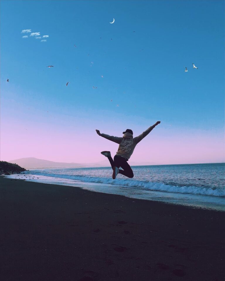 man jumping during sunset on a beach