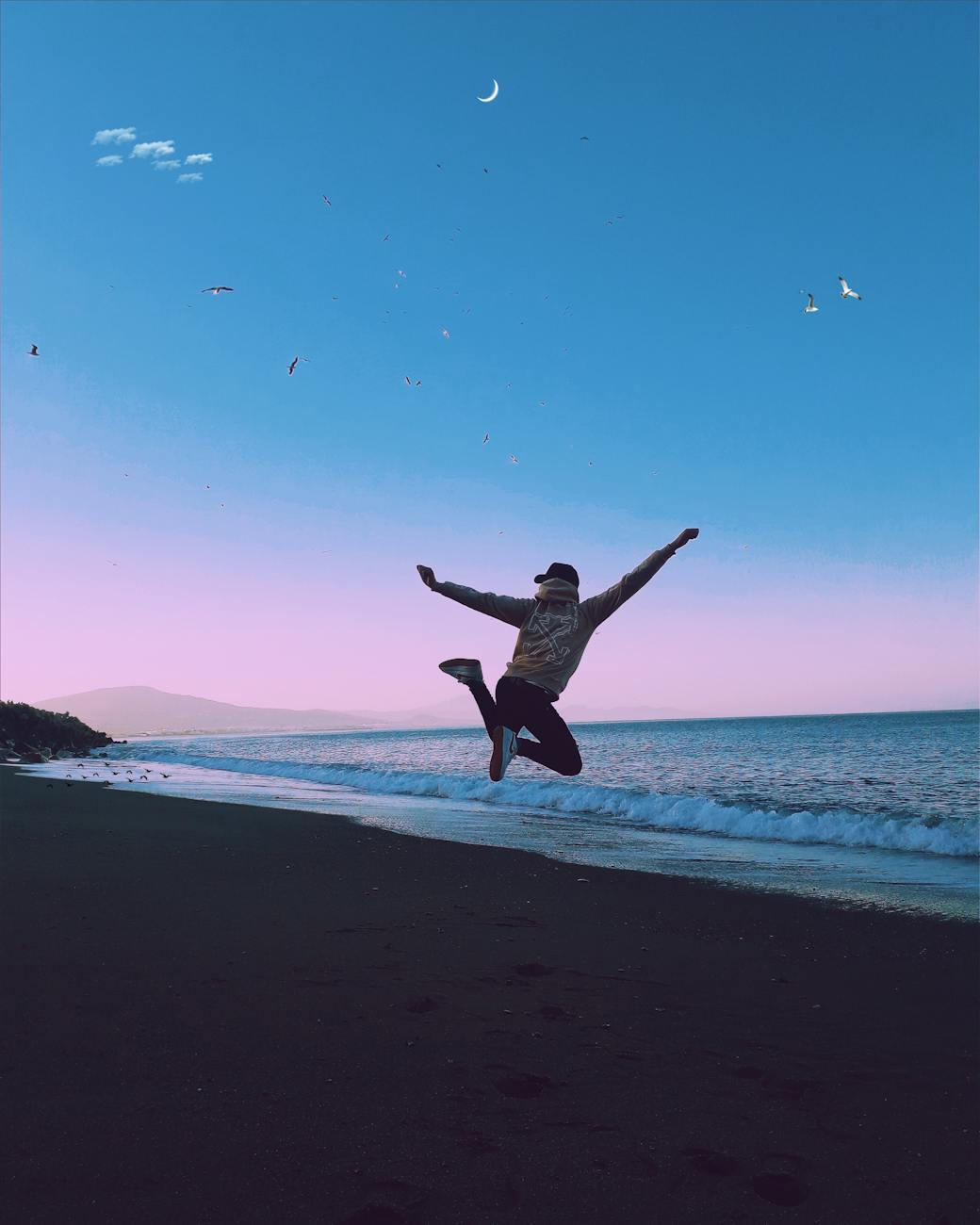 man jumping during sunset on a beach