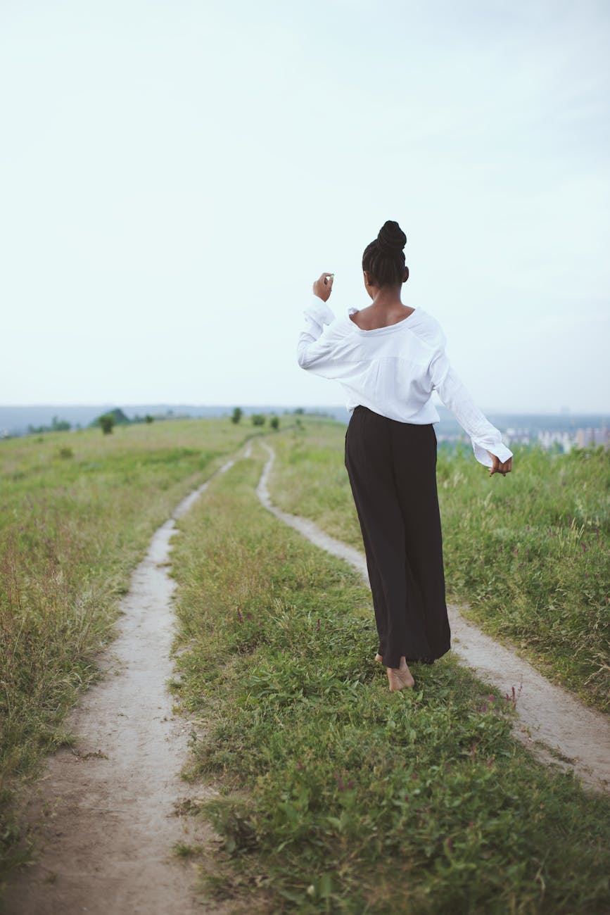 photo of woman walking on grass
