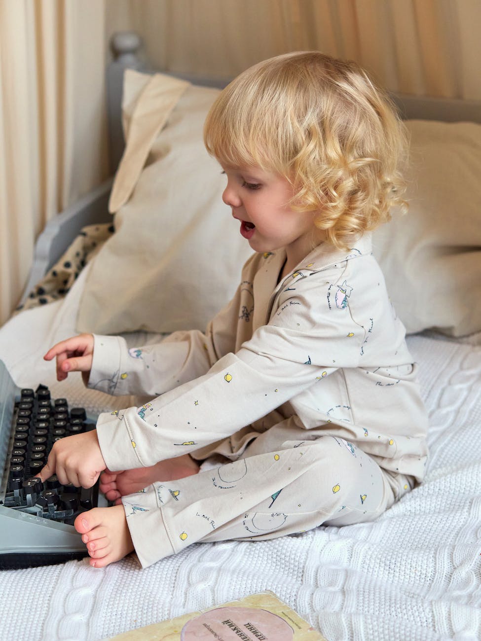 adorable child playing with vintage typewriter indoors