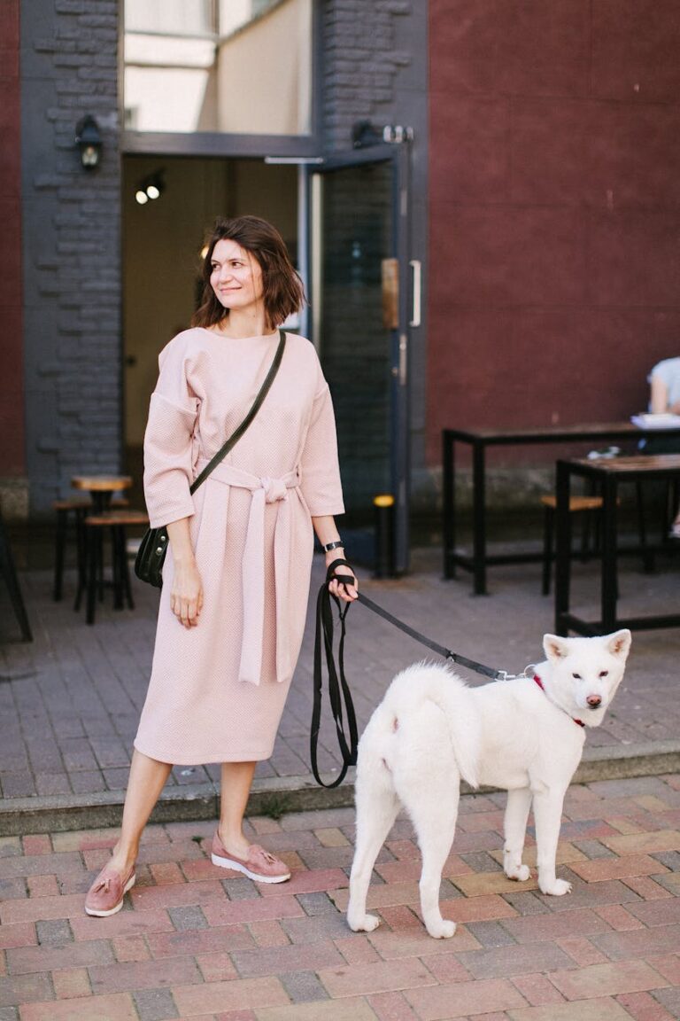 photo of woman wearing beige dress standing with a dog