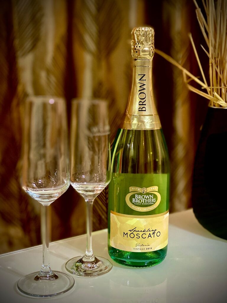 green wine bottle beside clear wine glasses