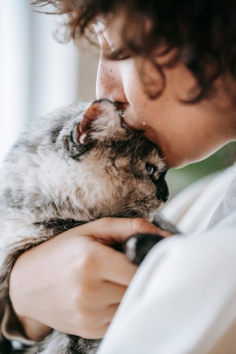 woman kissing cute fluffy spotty cat