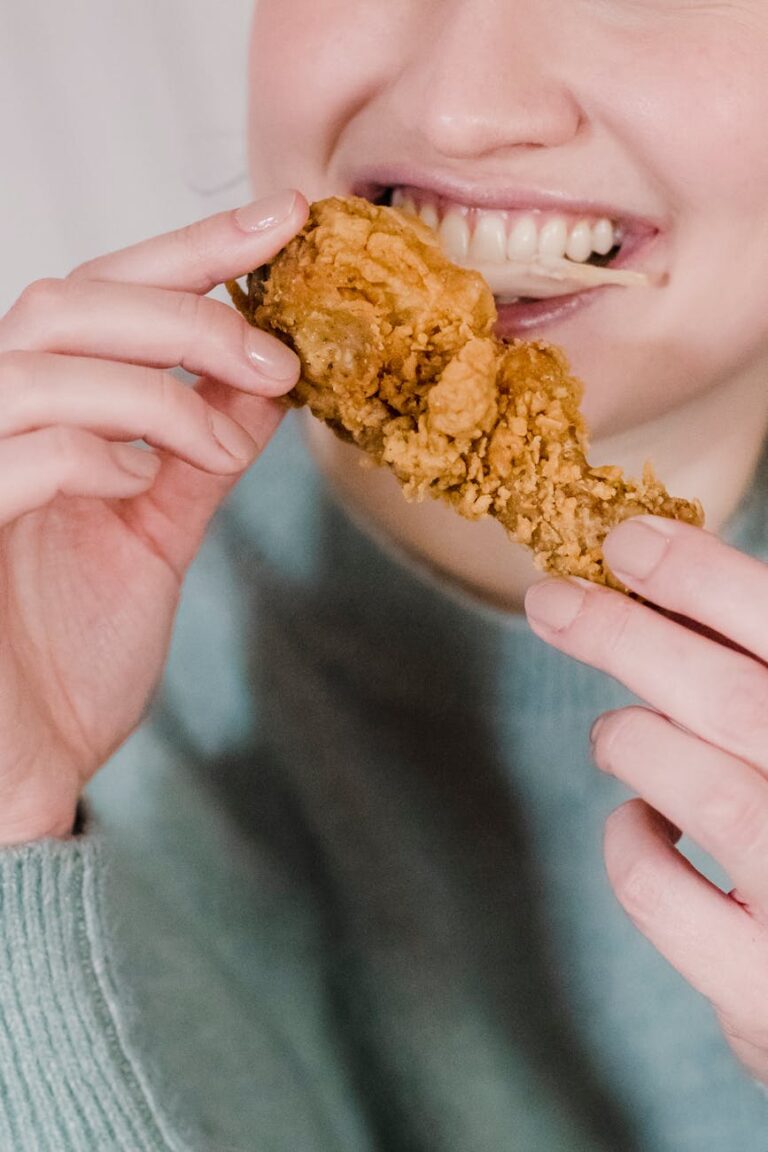 hungry woman biting fried delicious chicken