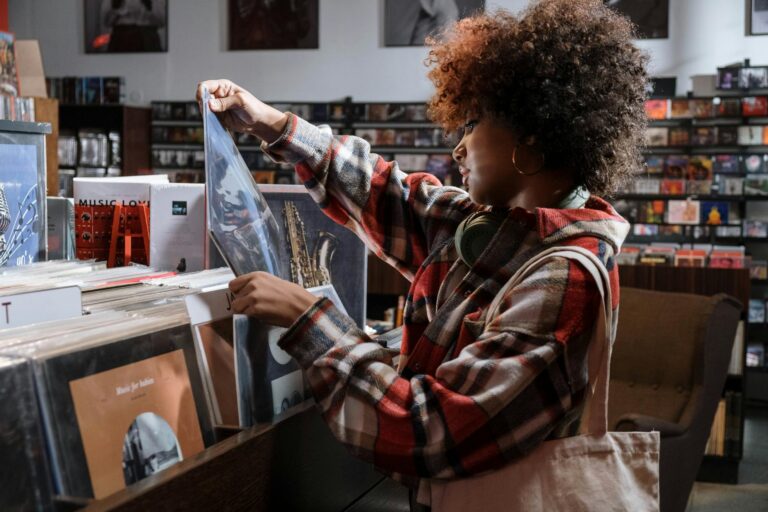 woman in red and white plaid shirt checking the vinyl record