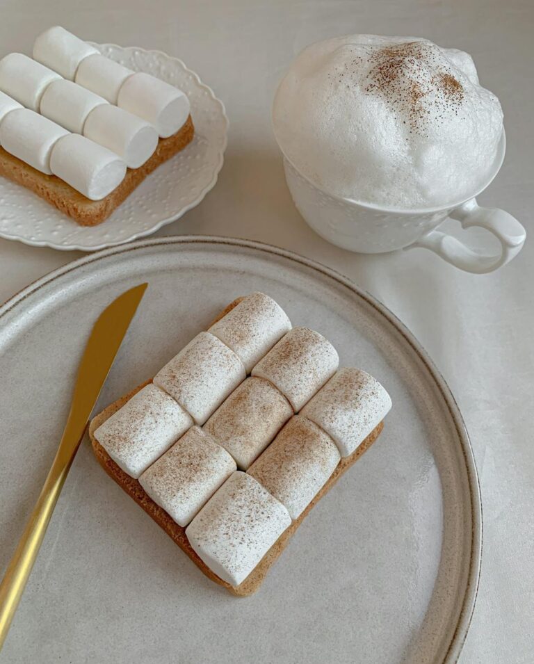 toast with marshmallows beside a cup with milk foam