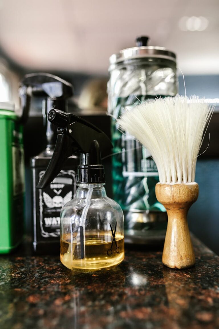 close up of a spray bottle beside a barber s brush