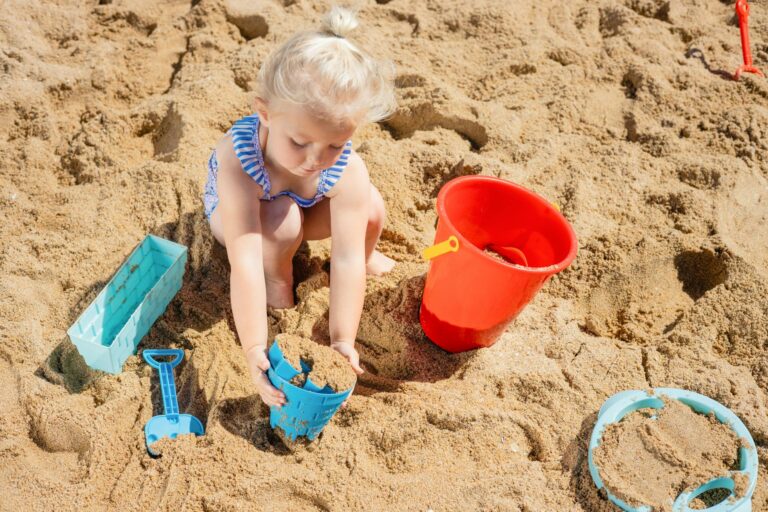 a young girl playing on the beach sand