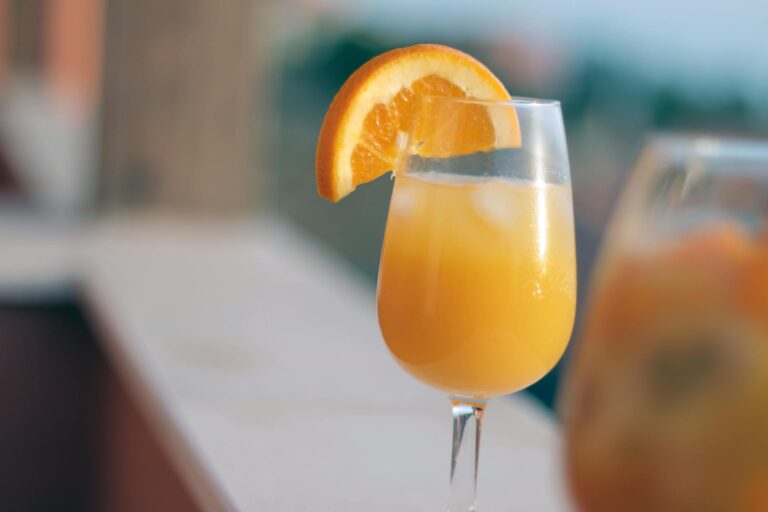 orange juice in clear drinking glass