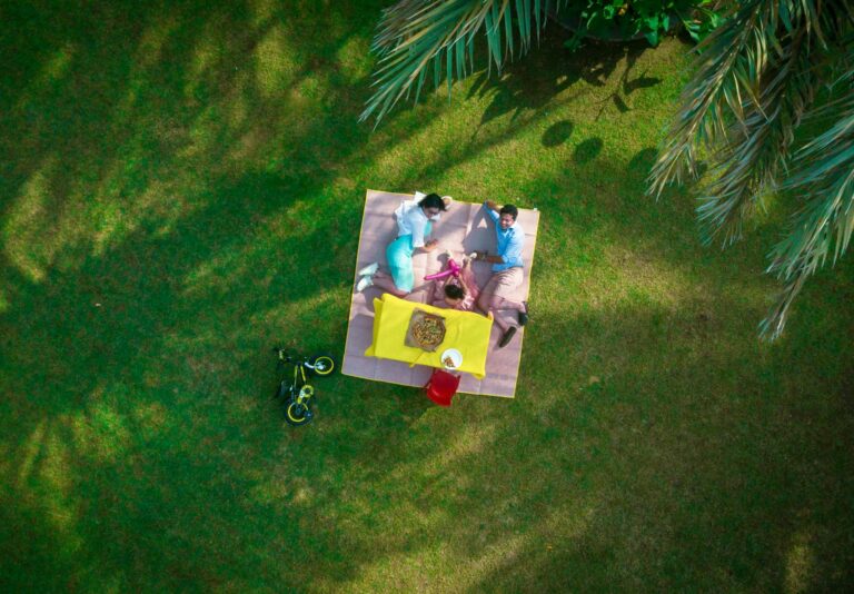 man and woman laying on picnic mat