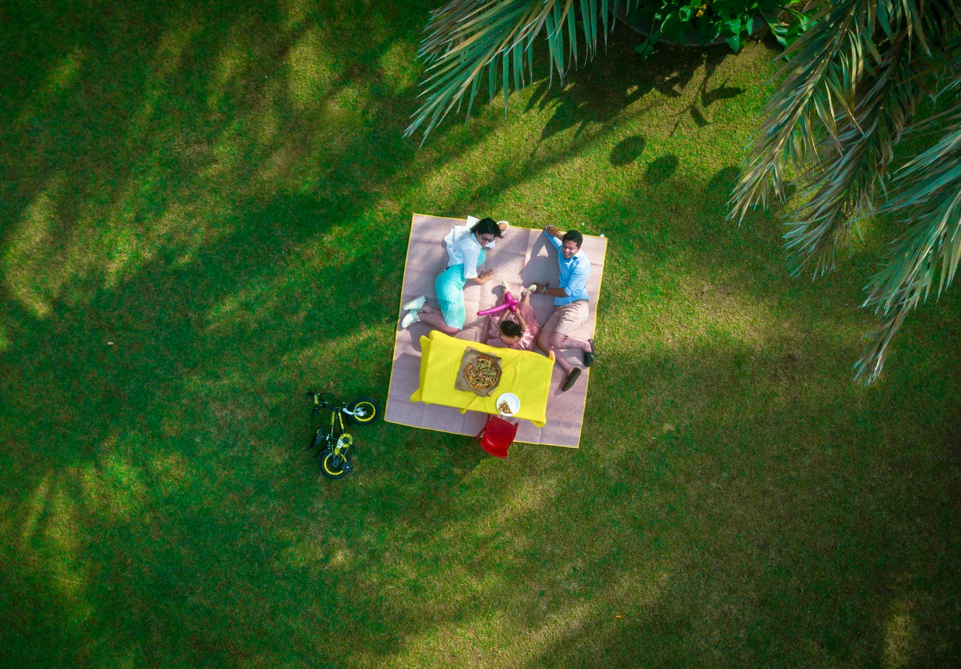 man and woman laying on picnic mat