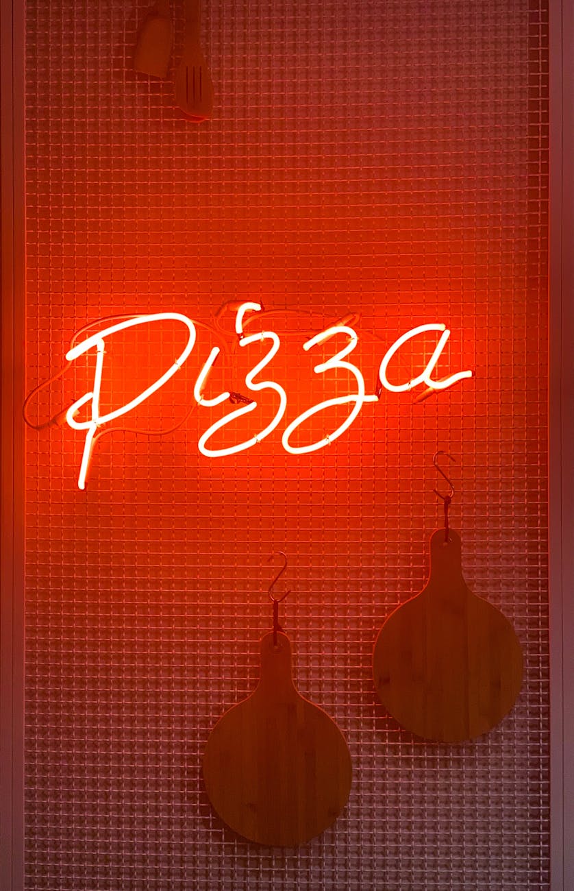 pizza neon light signage beside wall