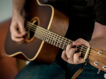 person playing brown guitar