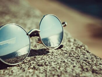 silver framed hippie sunglasses on concrete