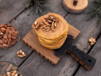 brown wooden chopping board with stack of pancakes