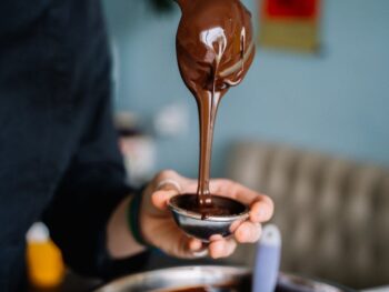 photo of person pouring chocolate on a silver mini bowl