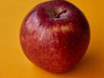 tasty red apple served on orange table