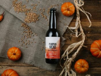 top view of pumpkins and a pumpkin bottled mead on a rustic table