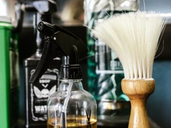 close up of a spray bottle beside a barber s brush